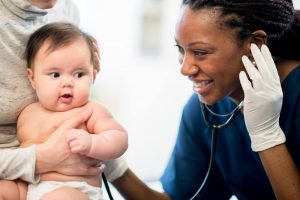 nurse with stethoscope on baby